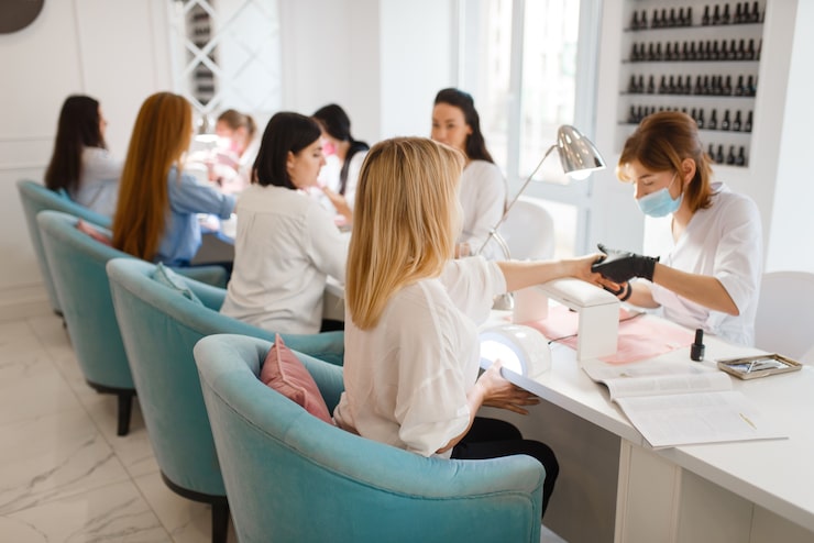 group-of-girlfriends-relax-on-manicure-procedure-in-beauty-salon