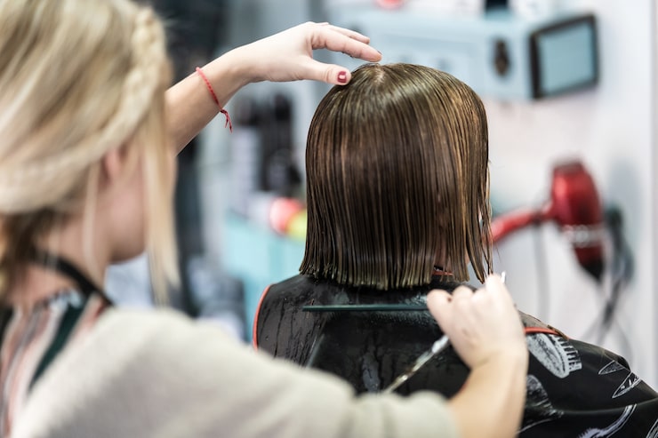 vertical-closeup-shot-of-a-hairdresser-cutting-a-womans-short-hair-in-a-beauty-salon